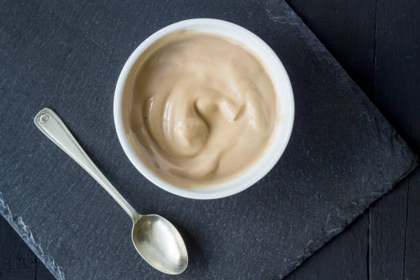 istock Chocolate flavoured yogurt in cup isolated on black slate background with space for text - overhead photo 1253860834