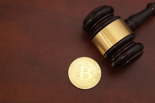 Crypto currency law concept, judge gavel and bitcoin symbol on table