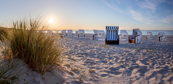 Canopied beach chairs at beach near Prerow (Darß Peninsula, Germany) in evening light