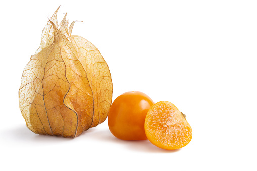 Group of ripe gooseberry, physalis, one cut in half, showing seeds and calyx isolated on white
