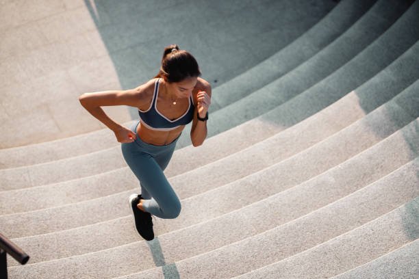 istock Caucasian young woman running at staircase 1253864818