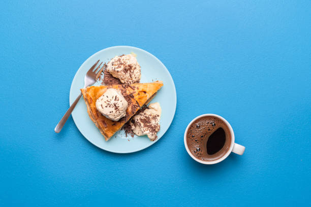 Apple pie with ice cream and cup of coffee. Top view of apple tart slice Apple pie slice with golden crust served with vanilla ice cream and a hot coffee on a blue table. Flat lay with an apple tart. Thanksgiving dessert. apple pie and ice cream stock pictures, royalty-free photos & images