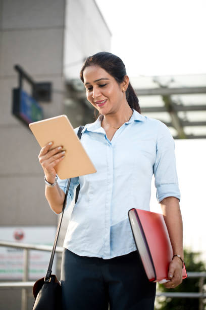 istock Businesswoman using digital tablet outside office building 1253874643