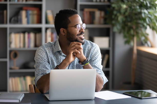 istock African male employee looking at window taking break from work 1253877148