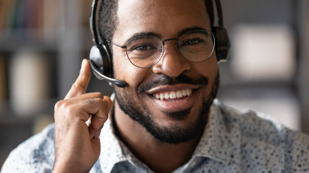 istock Closeup african man wear headset with microphone look at camera 1253877175