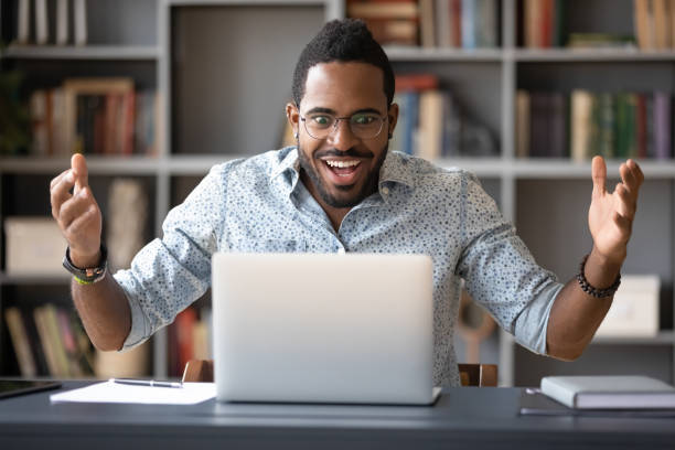 istock African guy looking at pc screen feels shocked 1253877179