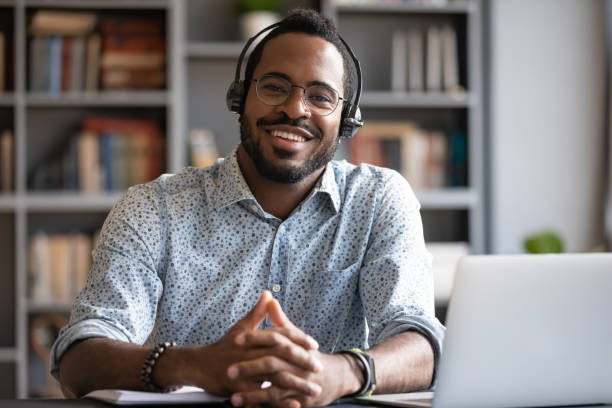 istock African man wear headset sit at desk looking at camera 1253877183