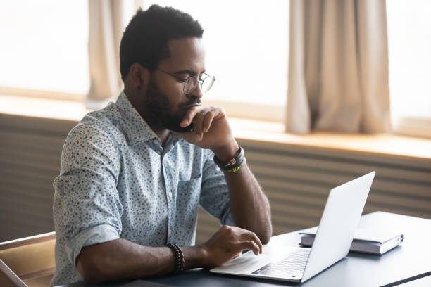 istock African man looking at laptop screen thinking over received email 1253877217