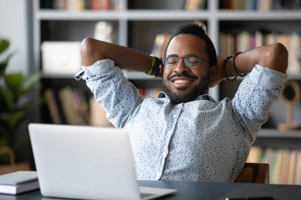 istock African guy put hands behind head takes break watching movie 1253877746