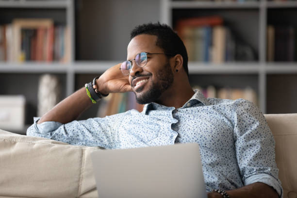 istock African guy distracted from using laptop daydreams looking at window 1253877773