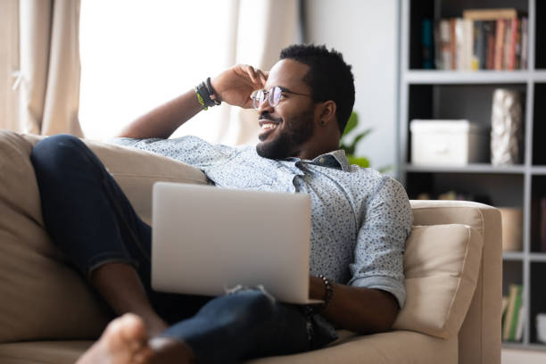 istock Single guy resting on couch in living room with notebook 1253877810
