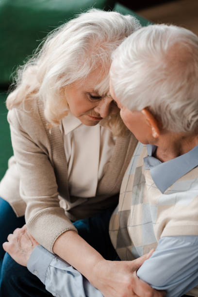istock sad elderly couple hugging at home on quarantine 1253878362
