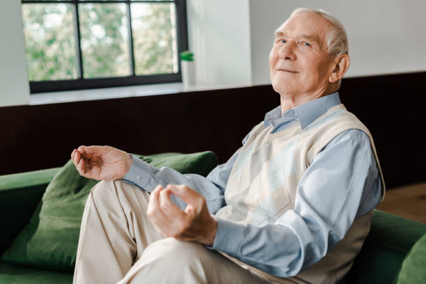 istock happy elderly man meditating on sofa at home during self isolation 1253878365