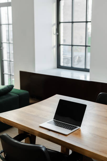 istock laptop with blank screen standing on table at home with window 1253878410