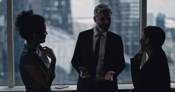 istock Multi ethnic business team talking. City panorama in background 1253878494