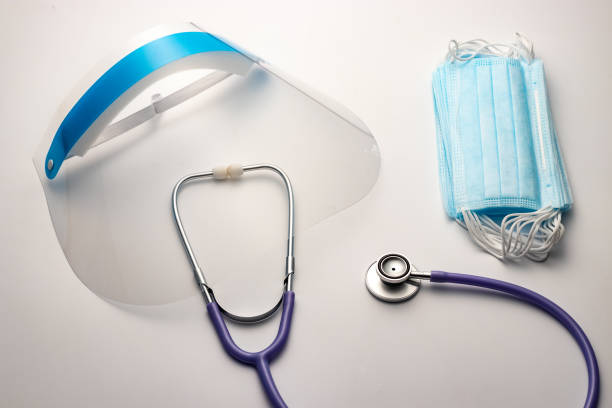 istock Doctor personal protective equipment concept. Stethoscope, face shield, mask. 1253879244