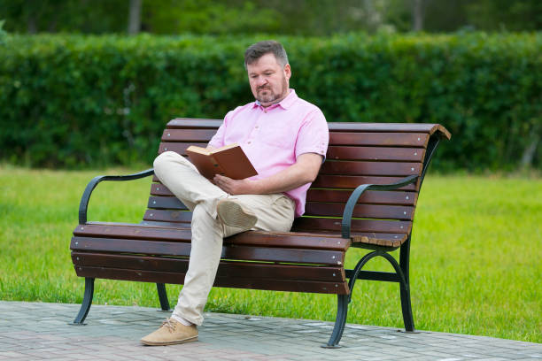 istock Caucasian man in a red shirt is reading a book. 1253880024