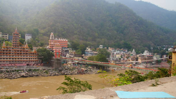 Blue yoga mat by the Laxman Jhula Bridge In Rishikesh India a blue yoga mat placed on the edge of the street overlooking the famous laxman jhula bridge by the holy river ganga in the world capital of yoga rishikesh in India. Bridging the world together in yoga.  Rishikesh – Yoga  stock pictures, royalty-free photos & images