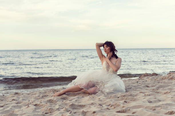 istock Bride in a white dress by the sea 1253887392