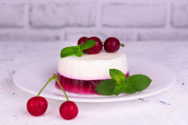 istock Panakota with cherry jelly and mint leaves on a white background. 1253889284