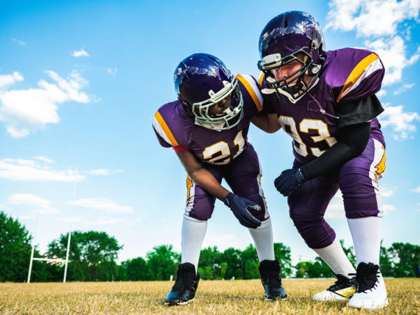 Two Junior Football players during practice game at the outdoor field.