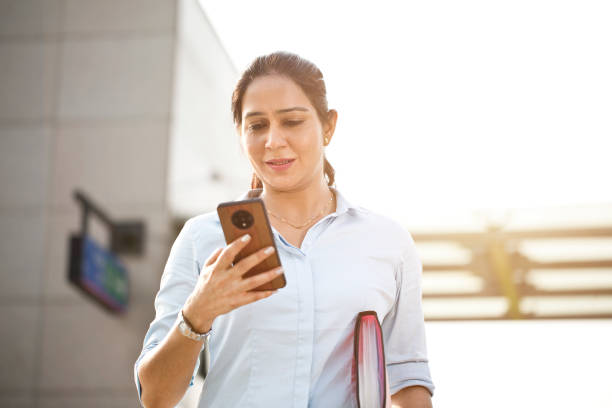 istock Successful businesswoman using mobile phone outside office building 1253891090