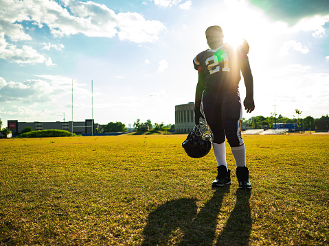 African American Junior Football player getting during game practice at the outdoor field.