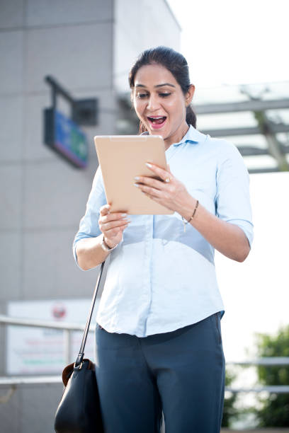 istock Businesswoman using digital tablet outside office building 1253891550
