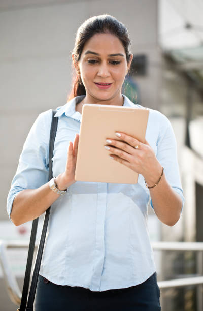 istock Businesswoman using digital tablet outside office building 1253892328