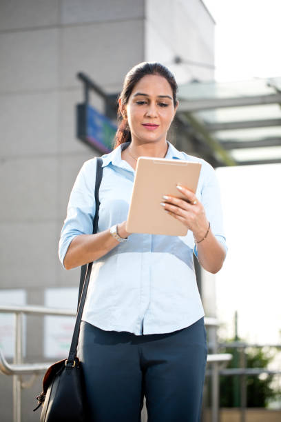 Businesswoman using digital tablet outside office building