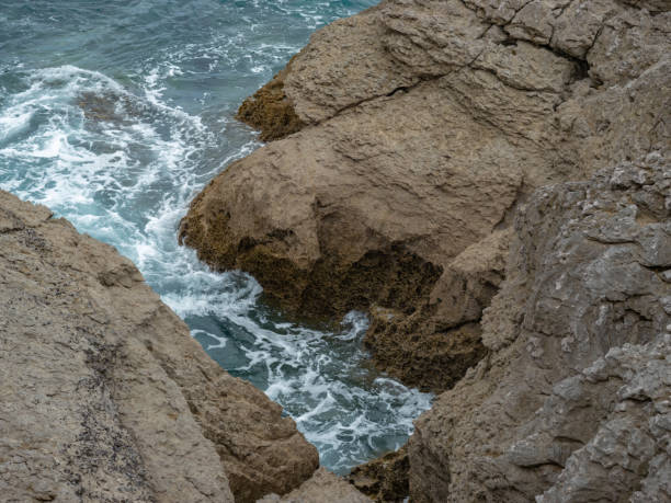 istock Waves of the sea breaking through cliffs 1253892826