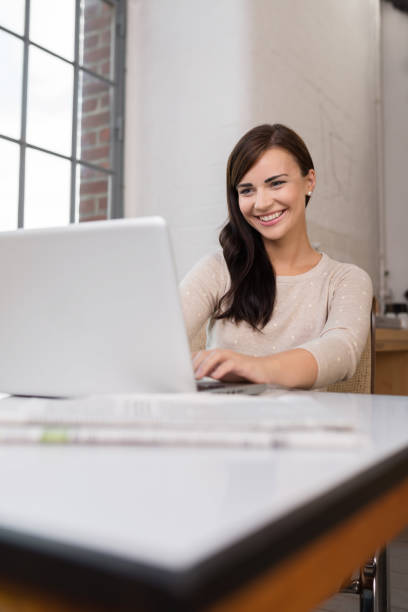 istock Smiling happy woman using a laptop 1253895091