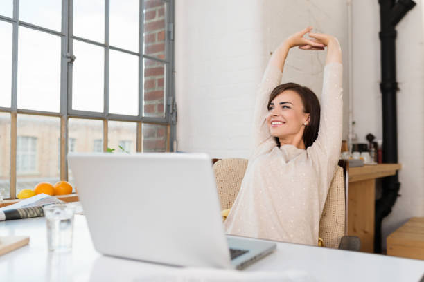 幸せなリラックスした若い女性は彼女の台所に座って - relaxation exercise stretching exercising women ストックフォトと画像