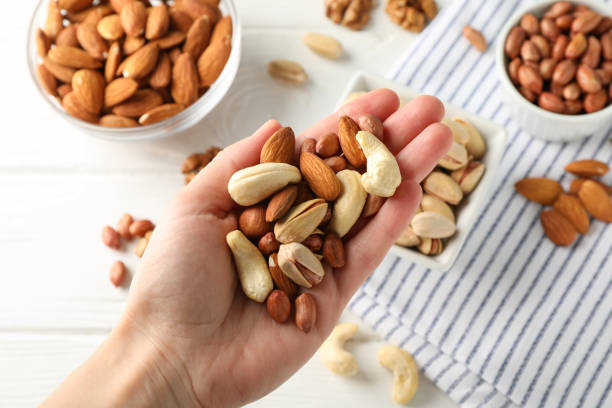 istock Female hand holds different nuts. Healthy eating 1253895942