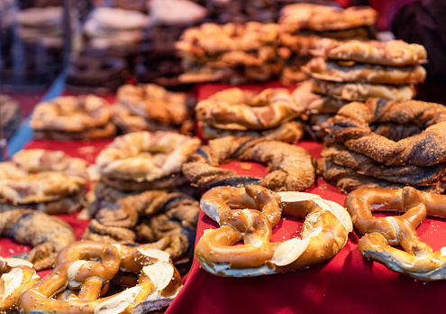 A variety of different types of pretzels, with plain salted ones in the foreground, on display at a traditional winter market stall in Frankfurt, Germany.