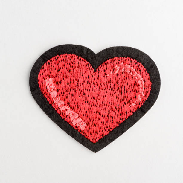 istock Close up on red heart embroidery patch on white background 1253897847