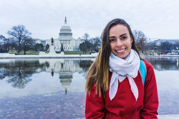 istock Beautiful tourist at the Capitol facing camera smiling 1253899040