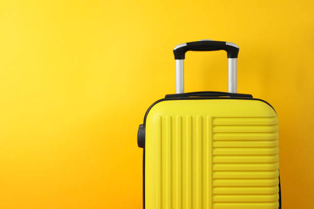 istock Color travel bag on yellow background, space for text 1253899087