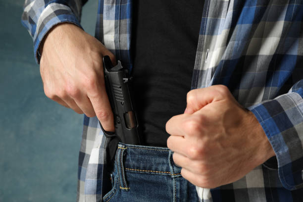 man takes out a gun from jeans, close up. robber - gun handgun violence kidnapping imagens e fotografias de stock