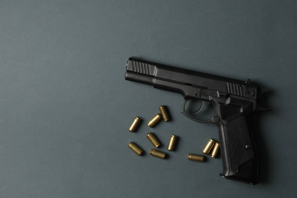 istock Pistol and traumatic bullets on dark gray background. Self defense weapon 1253900106