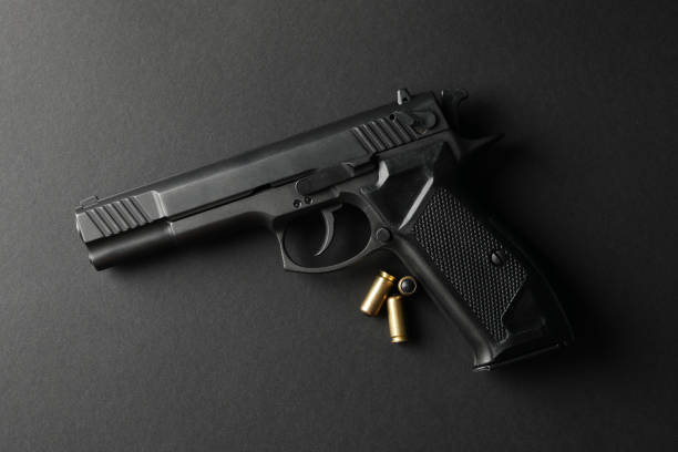 istock Pistol and traumatic bullets on black background. Self defense weapon 1253900191