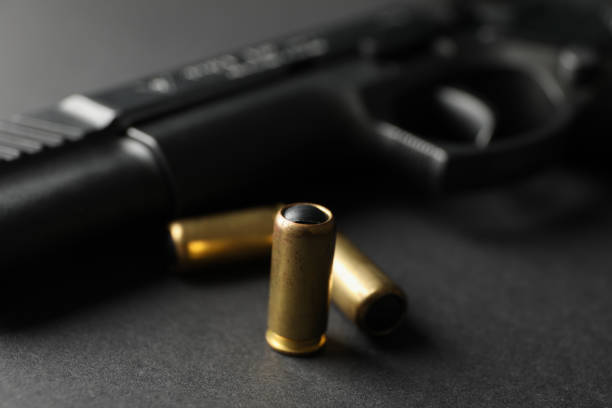 istock Pistol and traumatic bullets on black background. Self defense weapon 1253900233