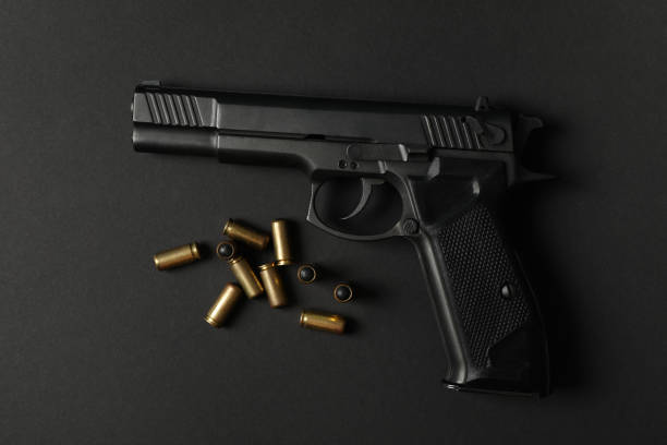 istock Pistol and traumatic bullets on black background. Self defense weapon 1253900256