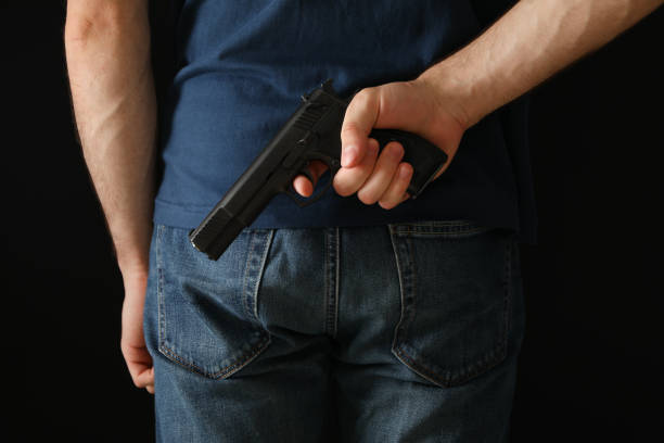 istock A man hold a gun from behind. Self defense weapon 1253900874
