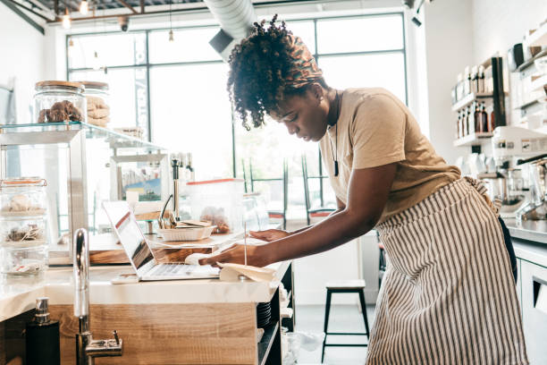 istock Young entrepreneur in her coffee shop working with receipts 1253901111