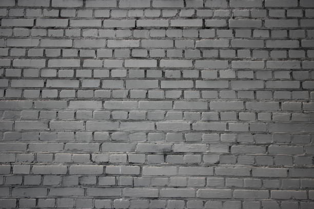 Weathered old grunge grey white brick wall background texture.