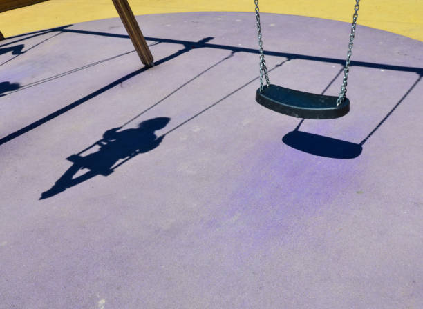 istock Shadow of a child on a swing, playground 1253901650