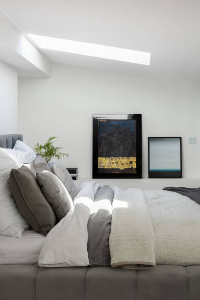 istock Elegant white bedroom with ceiling window 1253903532