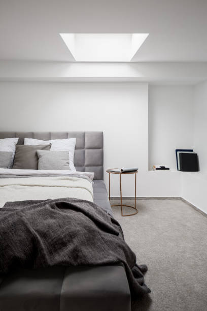 istock Stylish bedroom with gray quilted bed 1253903551