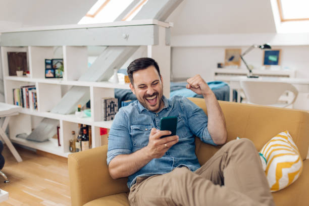 istock Excited man watching something on the smartphone and cheering 1253904328